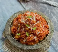 Reichhaltiges Safran-Karotten-Halwa, garniert mit knusprigen Pistazien, bietet ein süßes und aromatisches Dessert-Erlebnis.